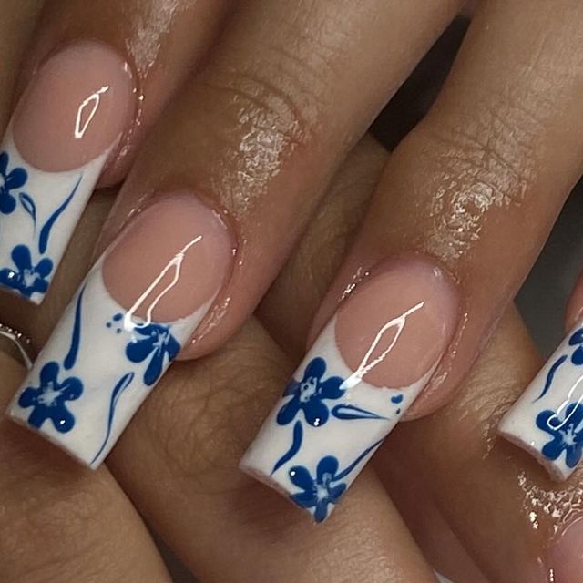 Chic Floral Nail Design: Deep Blue Flowers on White for a Modern Aesthetic.