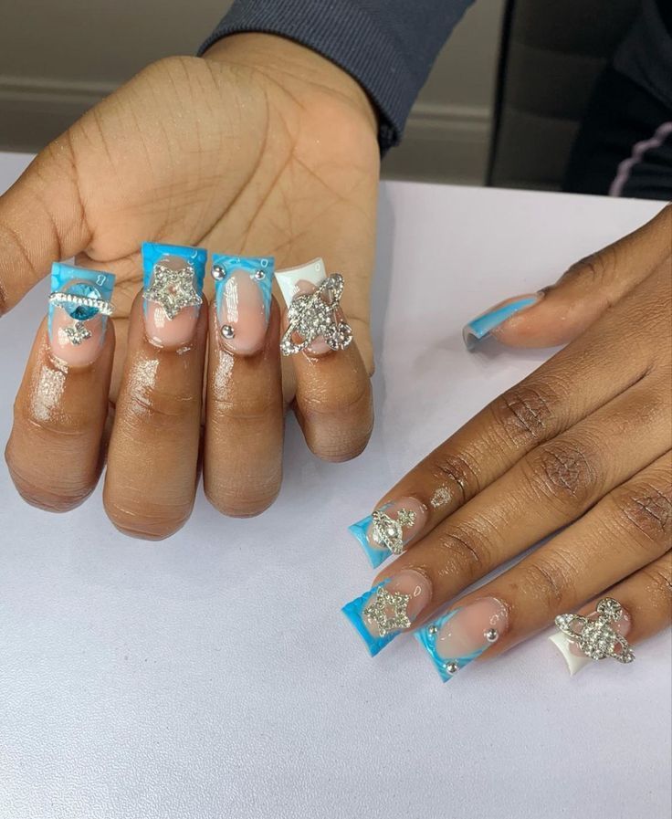 Vibrant Blue and White Nail Design with Intricate Jewels and Star Embellishments.