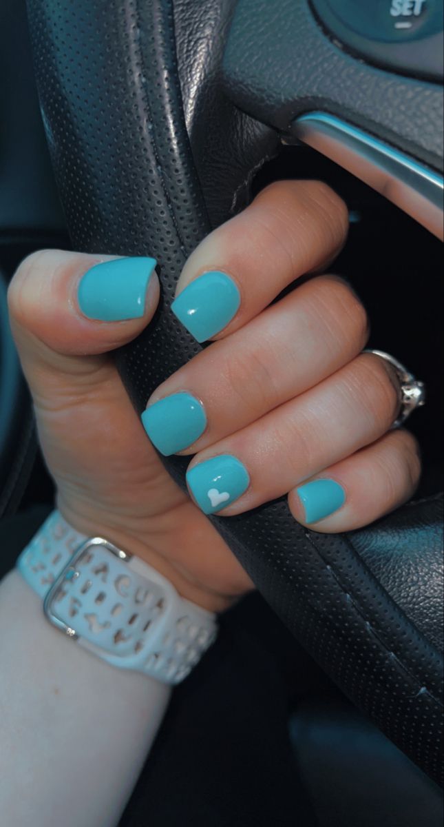 Elegant Vibrant Turquoise Nail Design with Delicate Heart Accent.