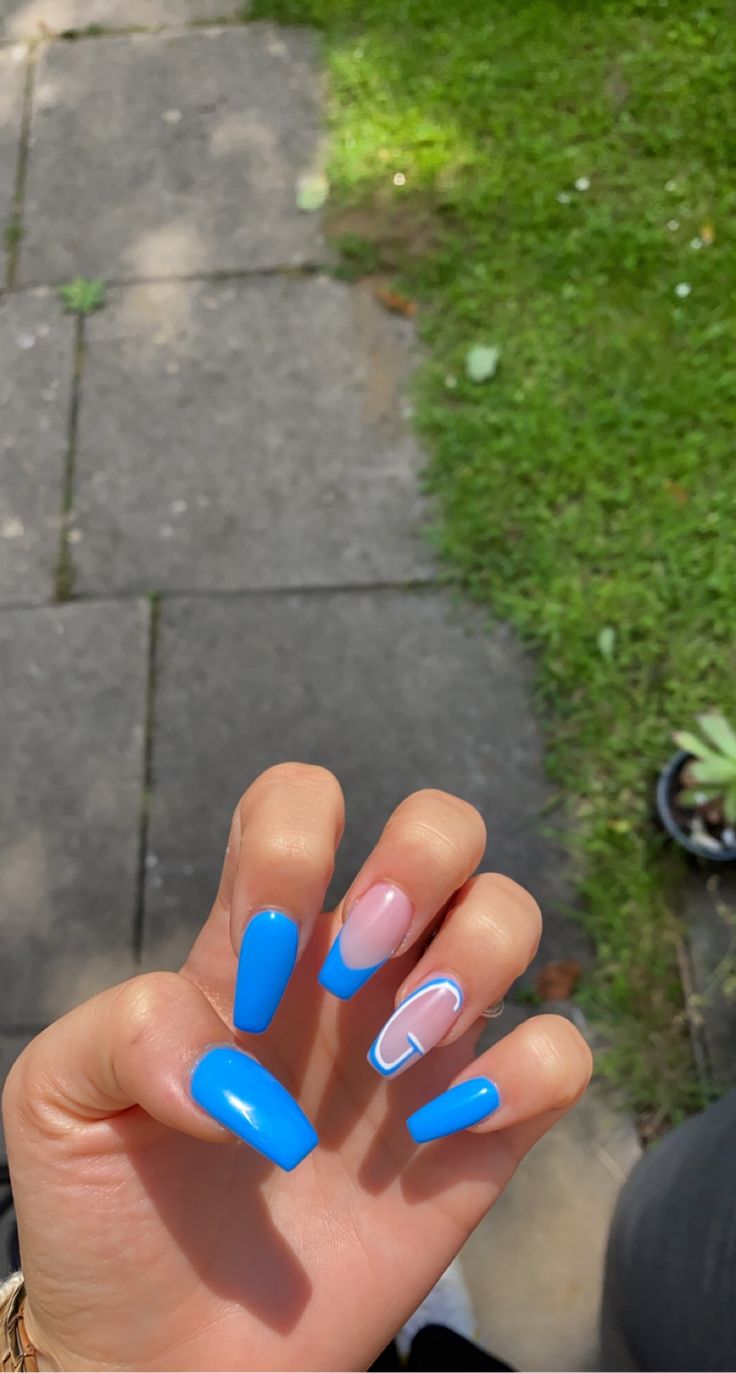 Stylish Playful Nail Art: Vibrant Blue and Nude Accents with Graphic Design.