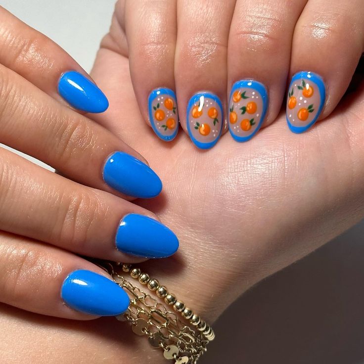 Cheerful Blue Nails with Playful Orange Fruit Designs for a Lively Summer Aesthetic.