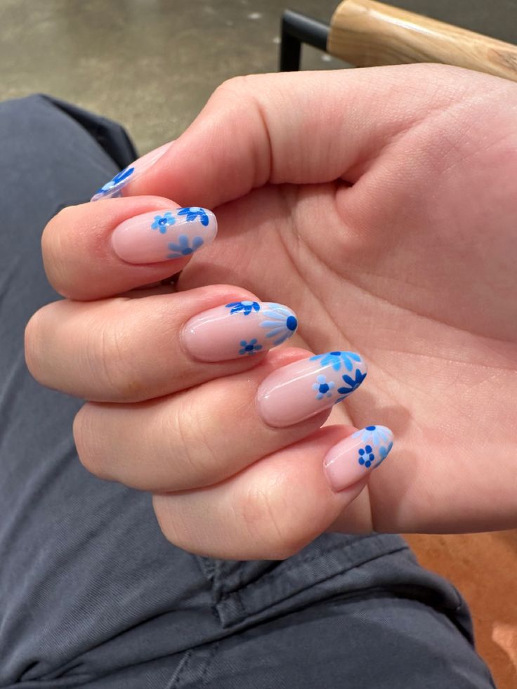 Charming Floral Nail Design: Soft Blue Blooms on Neutral Pink Base for a Fresh Spring Aesthetic.