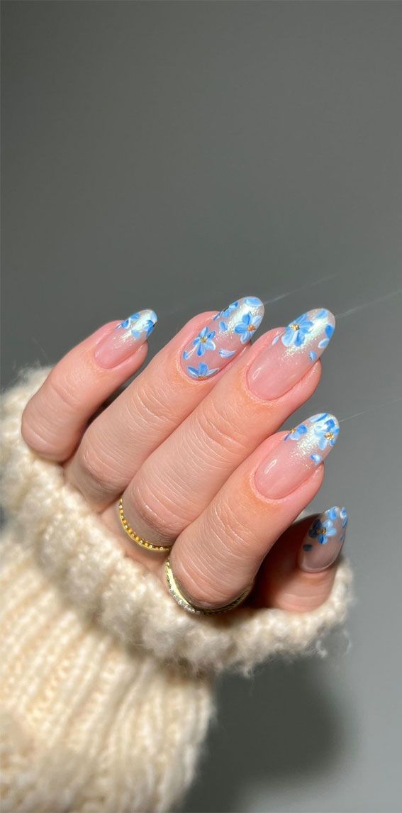 Charming Floral Nail Art: Delicate Blue Flowers on a Clear Base for a Fresh Spring Look.