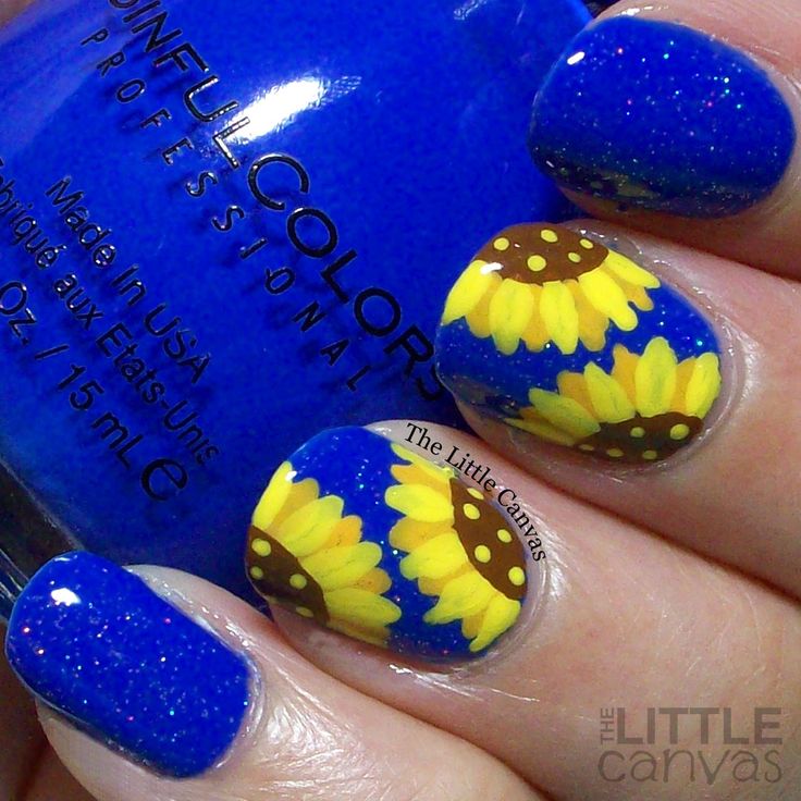 Cheerful Bright Blue Nail Design with Sunflower Accents and Sparkling Details.