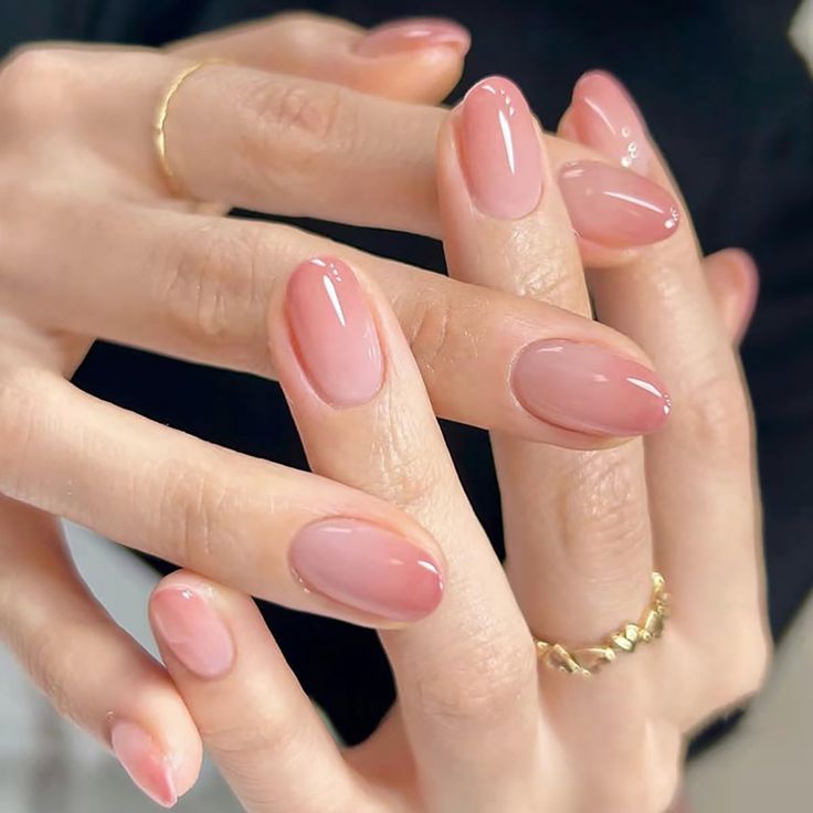 Elegant Nude Nail Design with Smooth Oval Tips and Soft Gradients, Accentuated by Simple Gold Jewelry.