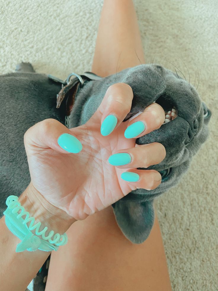 Elegant Turquoise Nail Design with Glossy Finish and Coordinating Accessory.