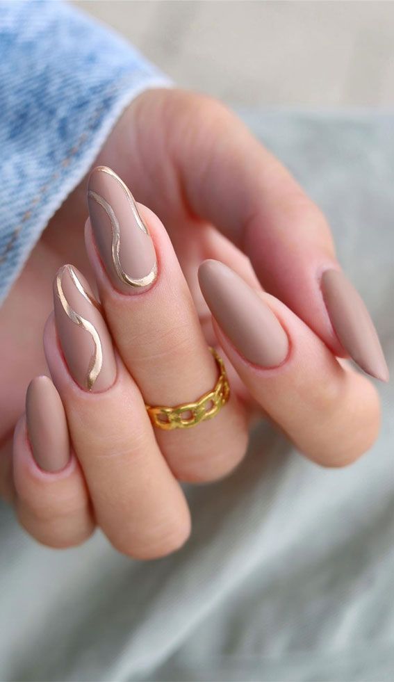 Sophisticated Nail Design: Muted Beige Base with Glossy Gold Waves