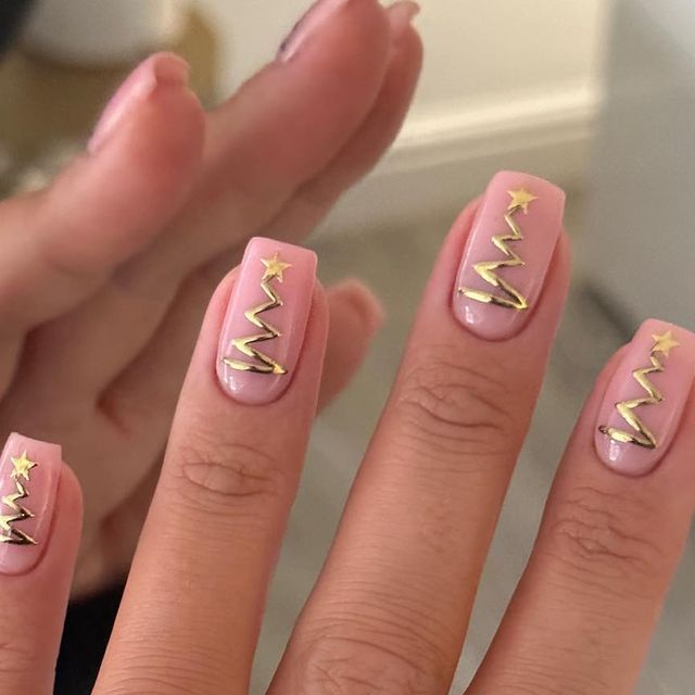 Chic Festive Nail Design: Soft Pink Base with Gold Accents and Holiday Cheer