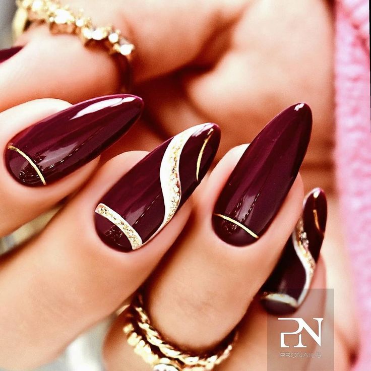 Glamorous Burgundy Almond Nails with Striking Gold Accents