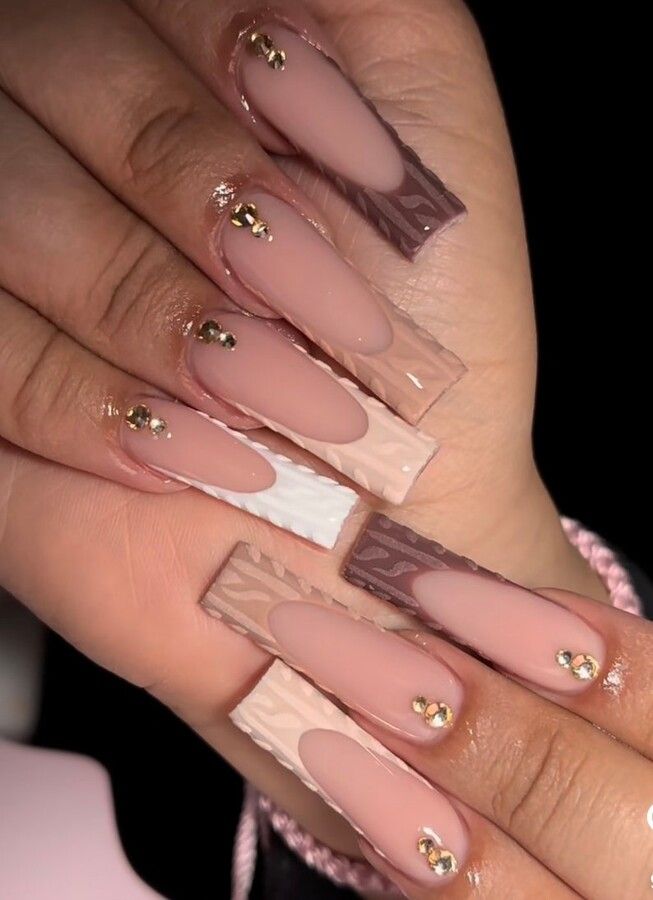 Chic Elongated Rectangular Nail Design with Textured Nude Shades and Gemstone Accents.