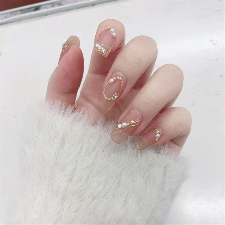 Elegant Soft Pink Nail Design with Intricate Gold Detail and Pearl Accents.