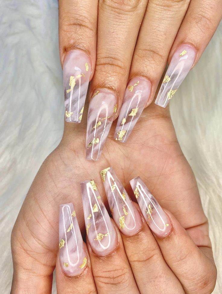 Elegant Long Nails with Glossy Pink and Transparent Designs Enhanced by Delicate Gold Flakes.