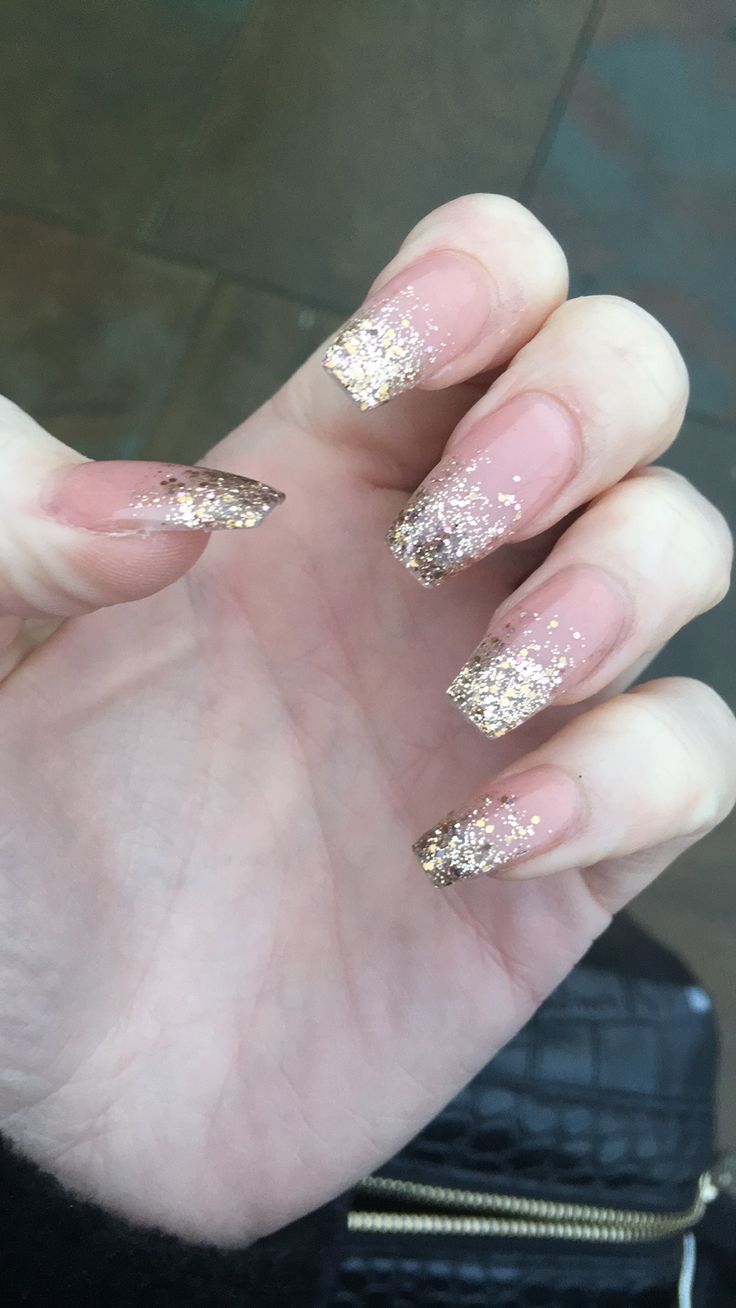 Elegant Sparkling Nail Design: Nude Base with Gold Glitter Tips and Gradient Effect.