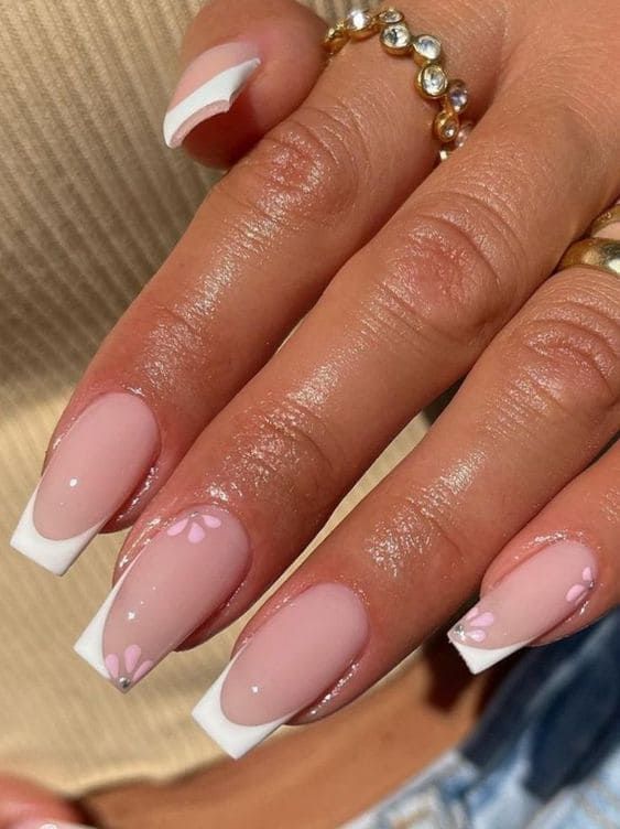 Sophisticated Soft Pink Nail Design with White French Tips and Floral Accents.