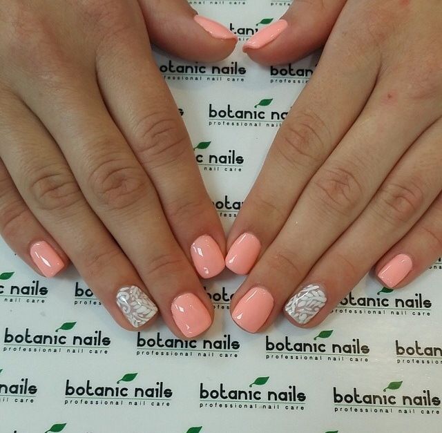 Elegant Pastel Peach Nails with Intricate White Accents for a Fresh, Versatile Look.