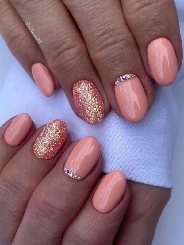 Chic Peach Nail Design with Gold Glitter and Rhinestone Accents.