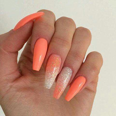 Glossy Vibrant Orange Stiletto Nails with Shimmering Glitter Flair.