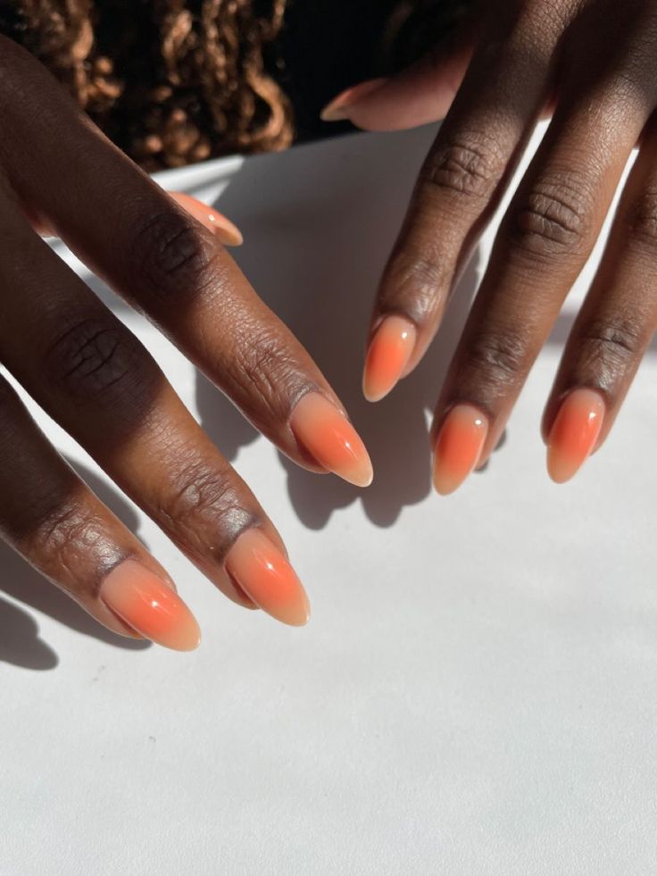 Elegant Ombre Nail Design: Warm Peach Gradient with Almond Shape.