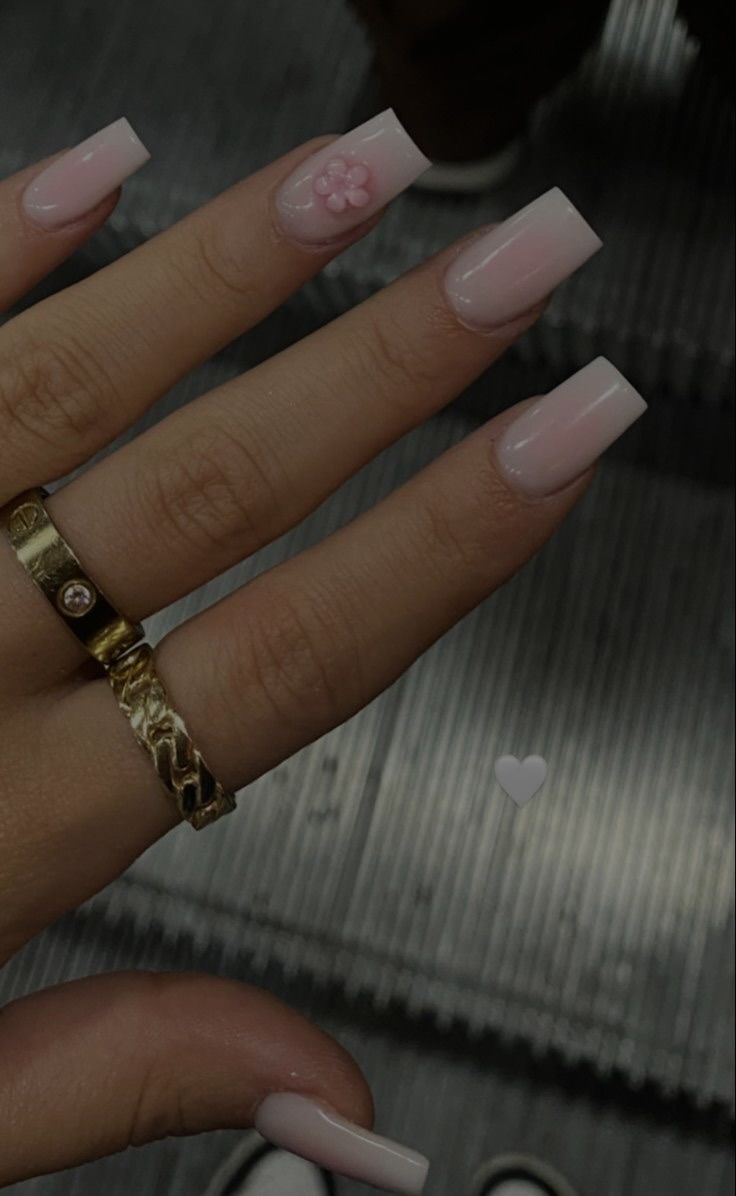 Elegant Soft Pink Nail Design with Floral Accent and Gold Ring.