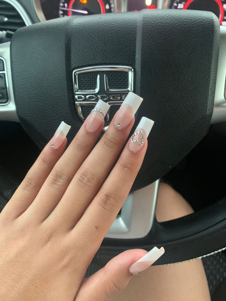 Chic French Tip Nail Design with Glamorous Accent and Soft Nude Base.