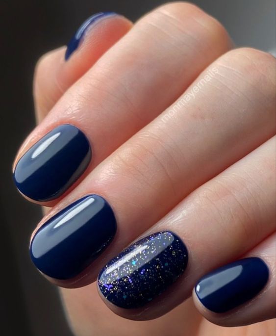 Striking Navy Blue Nails with Glitter Accent: A Sophisticated Yet Playful Design.