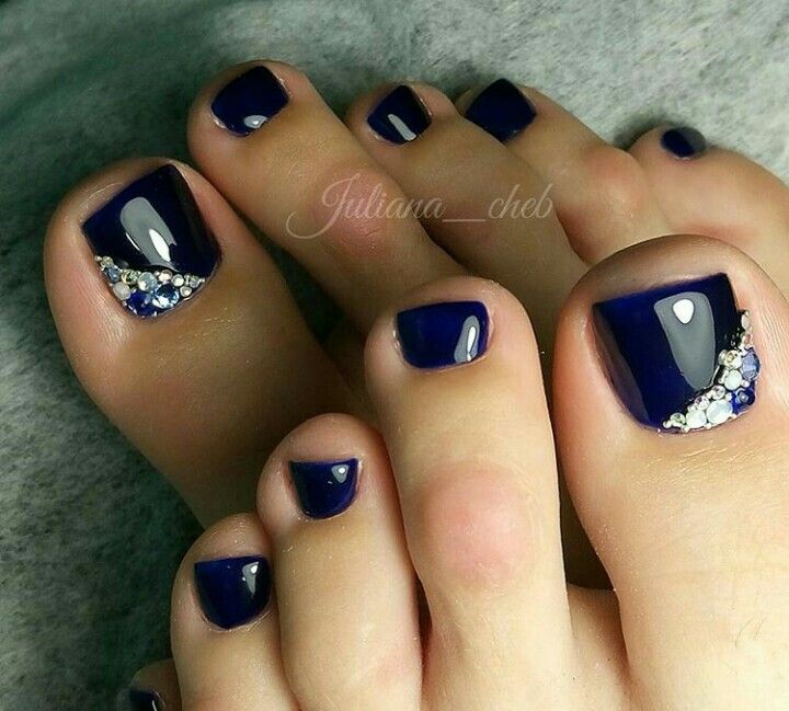 Chic Elegant Navy Toenail Design with Glossy Finish and Glamorous Embellishments.