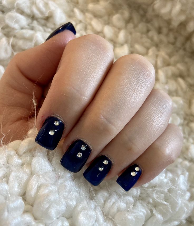 Chic Navy Blue Nail Art Design with Silver Rhinestones for Elegant Occasions.