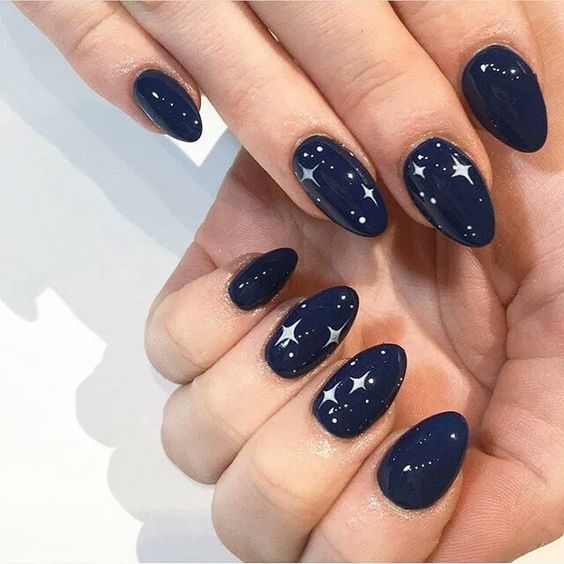 Elegant Starry Night Nail Design with Deep Navy Polish and Shimmering Motifs