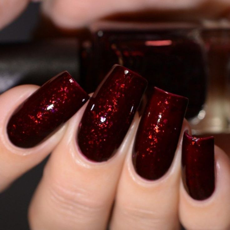 Luxurious Glossy Burgundy Nails with Shimmering Highlights for Elegant Evenings.