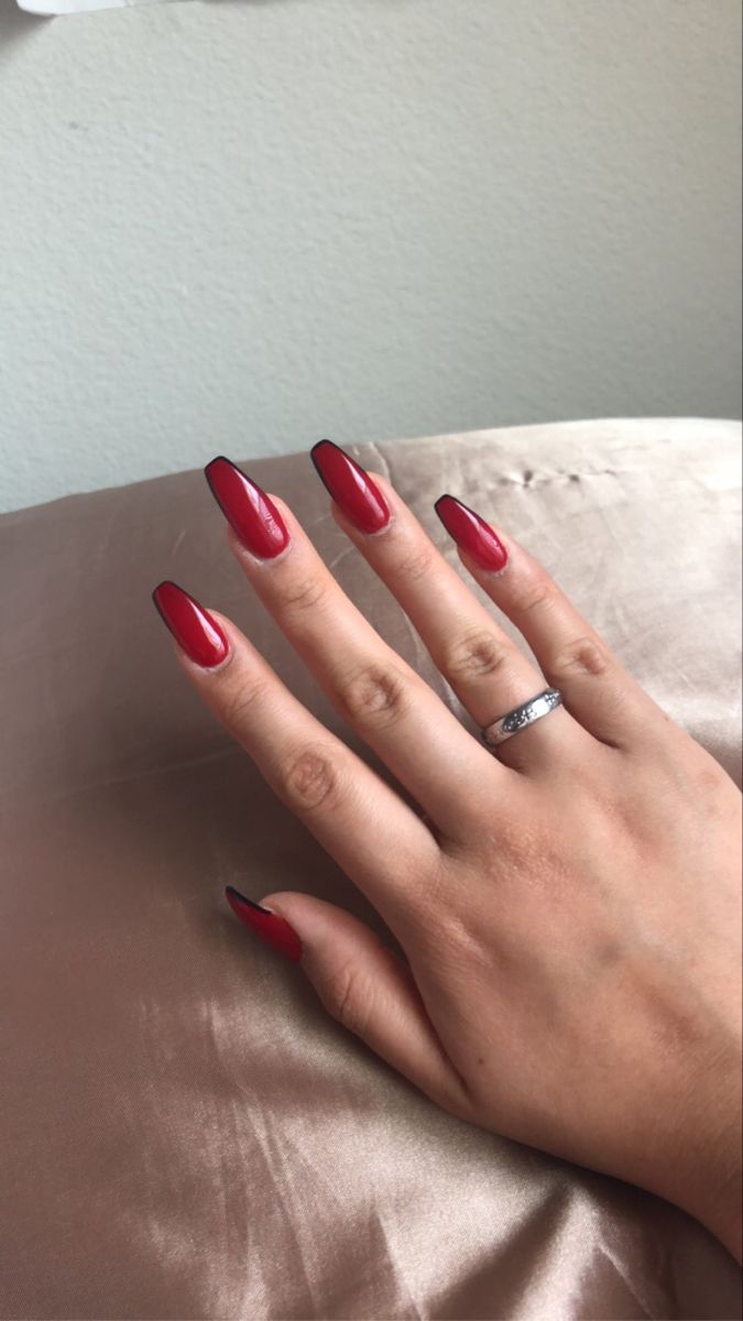 Chic and Edgy Glossy Red Nail Design with Gradient Tips and Black Outline.