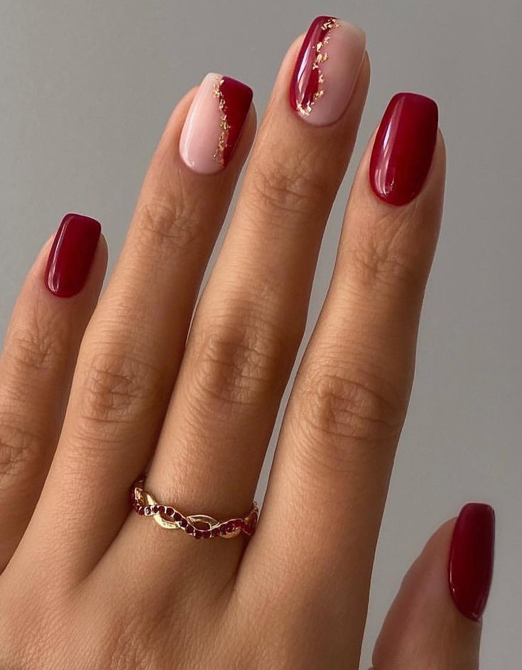 Sophisticated Burgundy and Nude Nail Design with Gold Accents