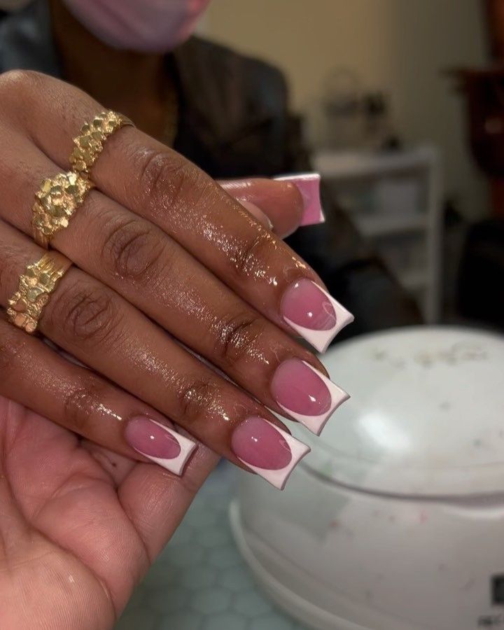 Stylish French Manicure with Soft Pink and Crisp White Tips, Accented by Gold Rings.