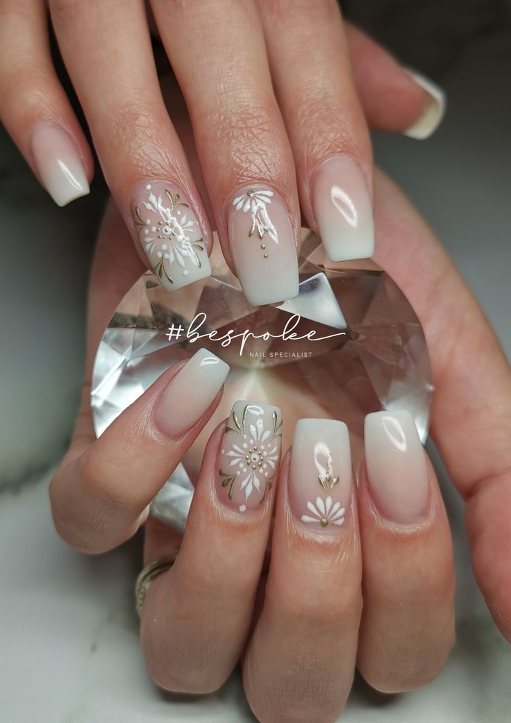 Sophisticated Ombre Nail Design with Floral Patterns and Glossy Accents for Special Occasions.