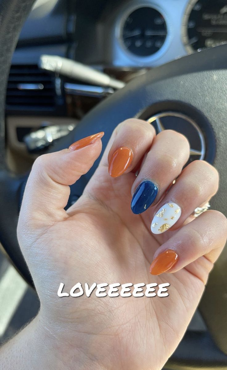 Chic Autumn-Inspired Nail Design with Burnt Orange, Navy Blue, and Gold Accents on Almond-Shaped Nails