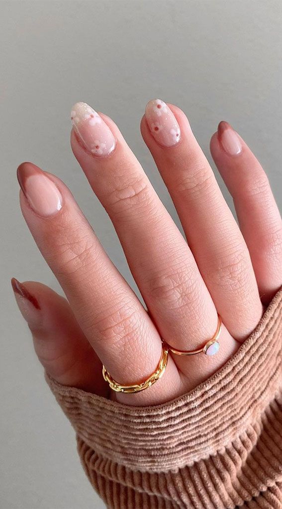 Chic French Tip Nail Design with Nude and Soft Pink Accents and Gold Ring Accents.