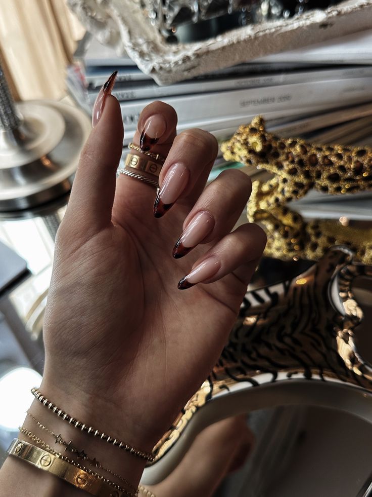 Sophisticated Gradient Nude to Dark Red Nail Design with Glamorous Finish and Gold Accents.