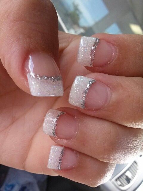 Elegant French Tip Nail Design with Shimmering Glitter and Delicate Silver Accents.