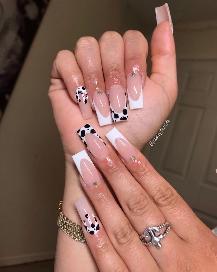 Trendy Nail Design: Chic Nude and White Base with Bold Polka Dots and Rhinestone Accents