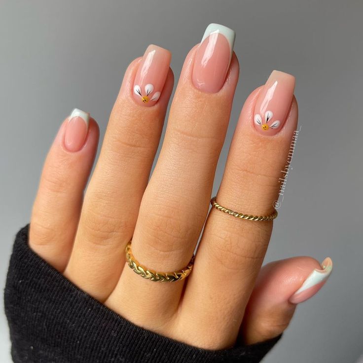 Chic Soft Pink Nail Design with White French Tips and Floral Accents