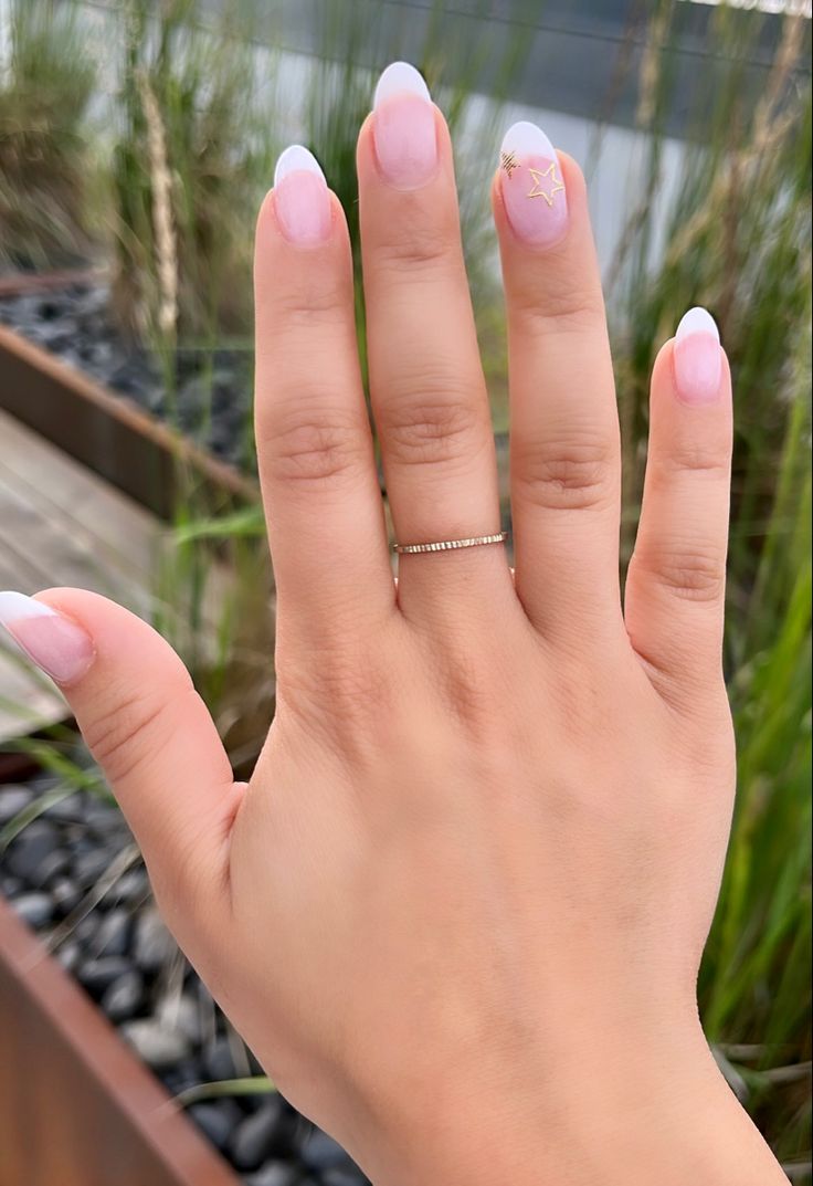 Sophisticated French Manicure with Soft Pink Shades and Playful Star Accent.