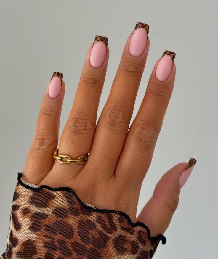 Chic Nude Pink Nails with Bold Leopard Print Tips: A Stylish and Playful Manicure.