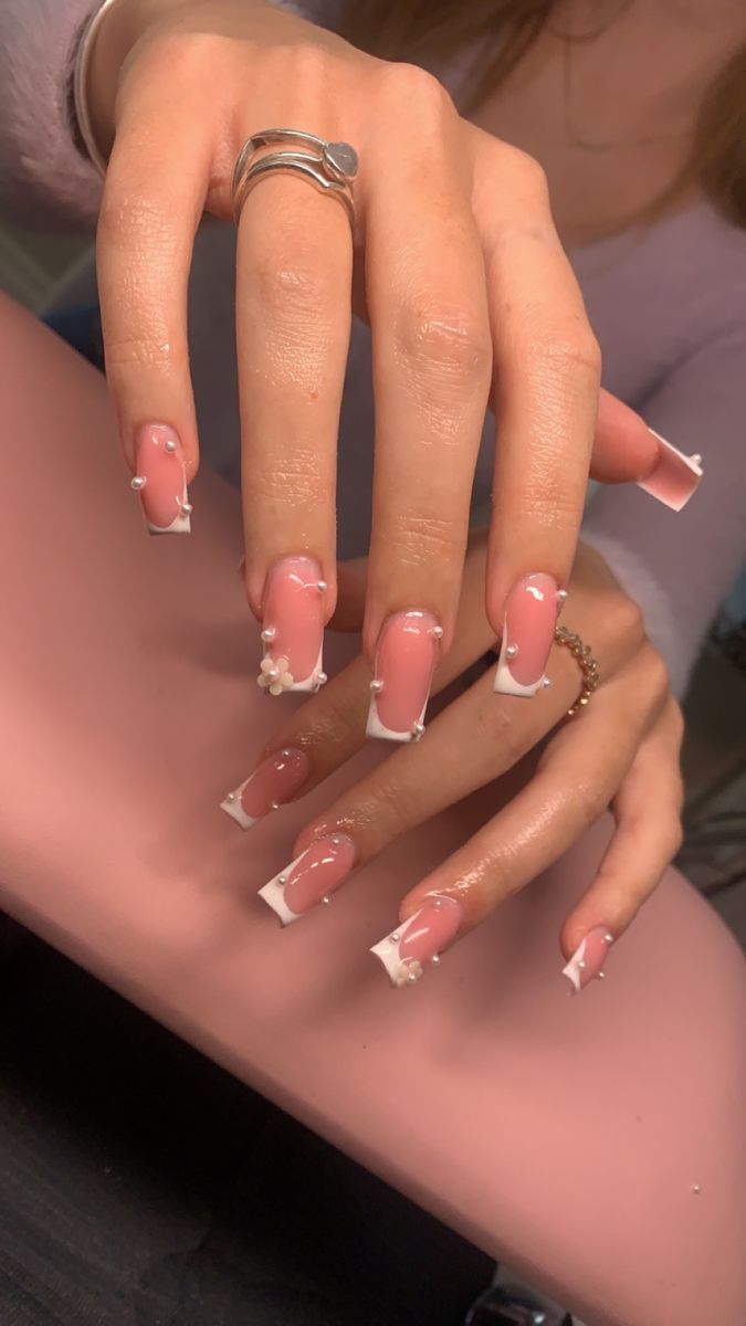 Trendy Elegant Nail Design: Delicate Pink Base with Striking White Tips and Sophisticated Embellishments.