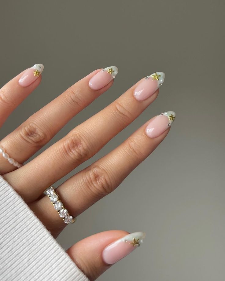 Sophisticated Soft Pink Nail Design with White Tips and Gold Star Accents