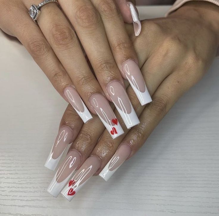 Elegant French Tip Nails with Playful Red Hearts for Romantic Occasions.