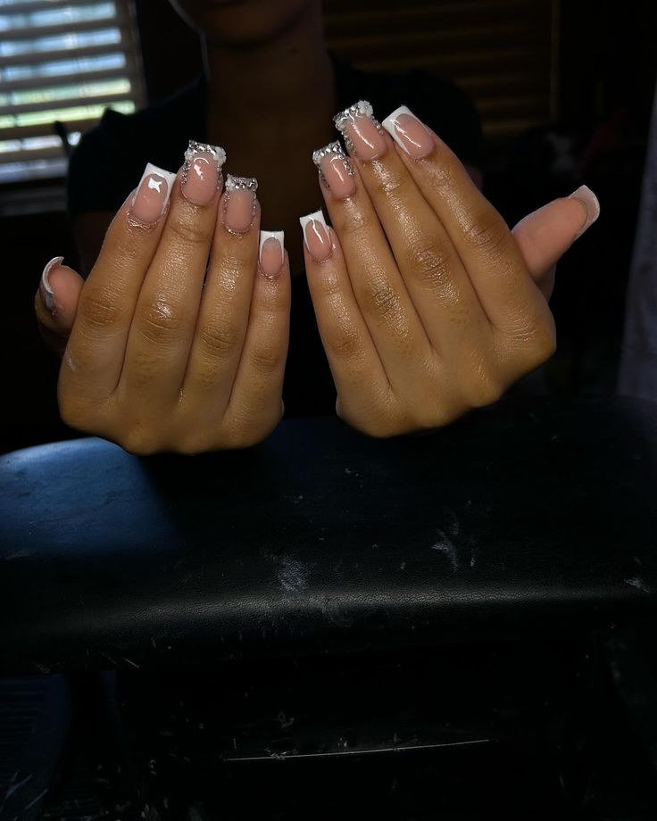 Chic Nude and White Nail Design with Rhinestone Accents.