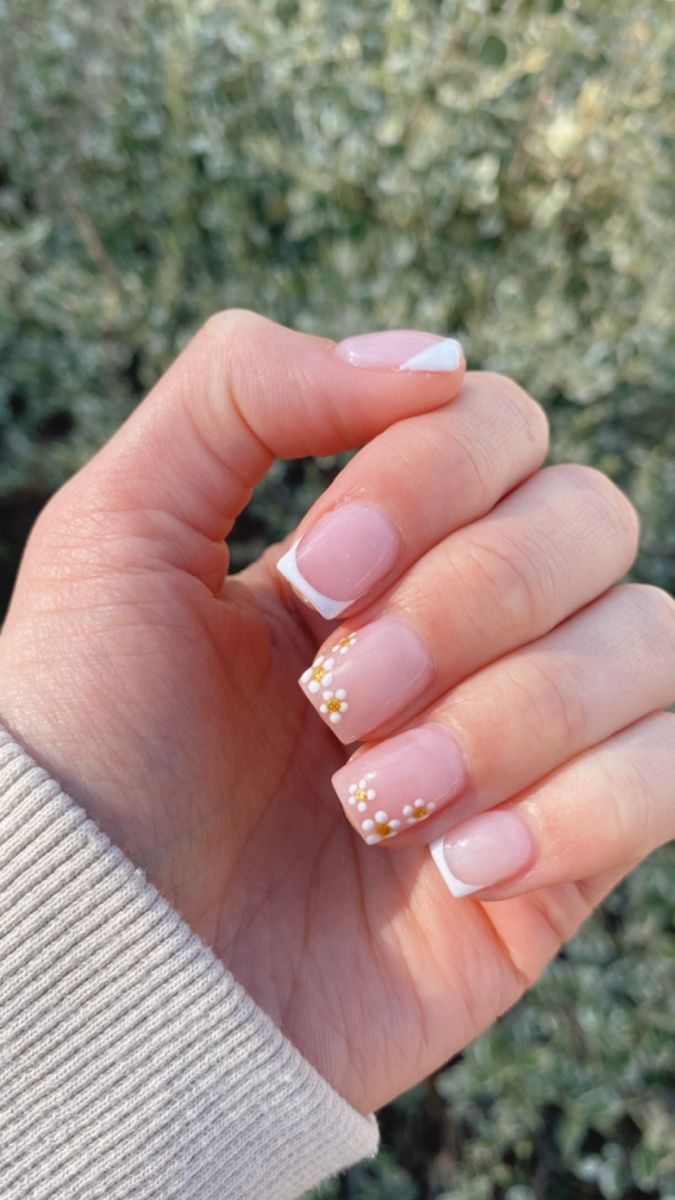 Whimsical Soft Pink Nail Design with White Tips and Floral Embellishments