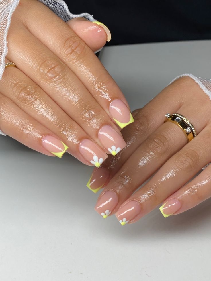 Charming Summer Nail Design with Nude Base, Yellow Tips, and Delicate White Flowers.