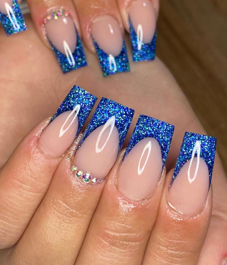 Striking Ombre Blue Glitter Nail Design with Rhinestone Accents.