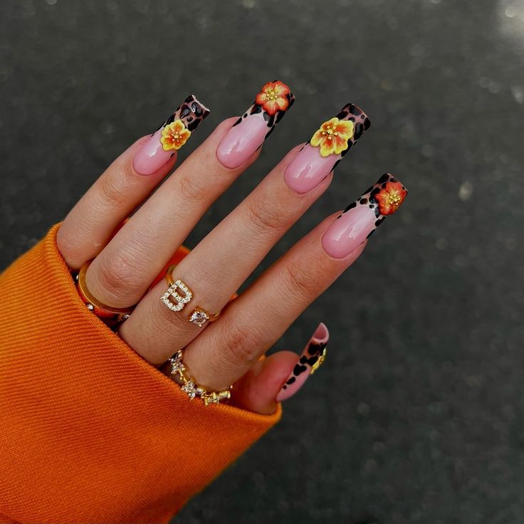 Vibrant Floral Elongated Nail Design with Leopard Accents and Elegant Gold Accessories.