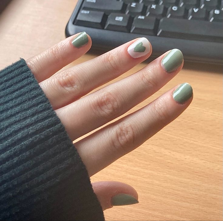 Whimsical Matte Green Nail Design with Heart Accent for Everyday Elegance.